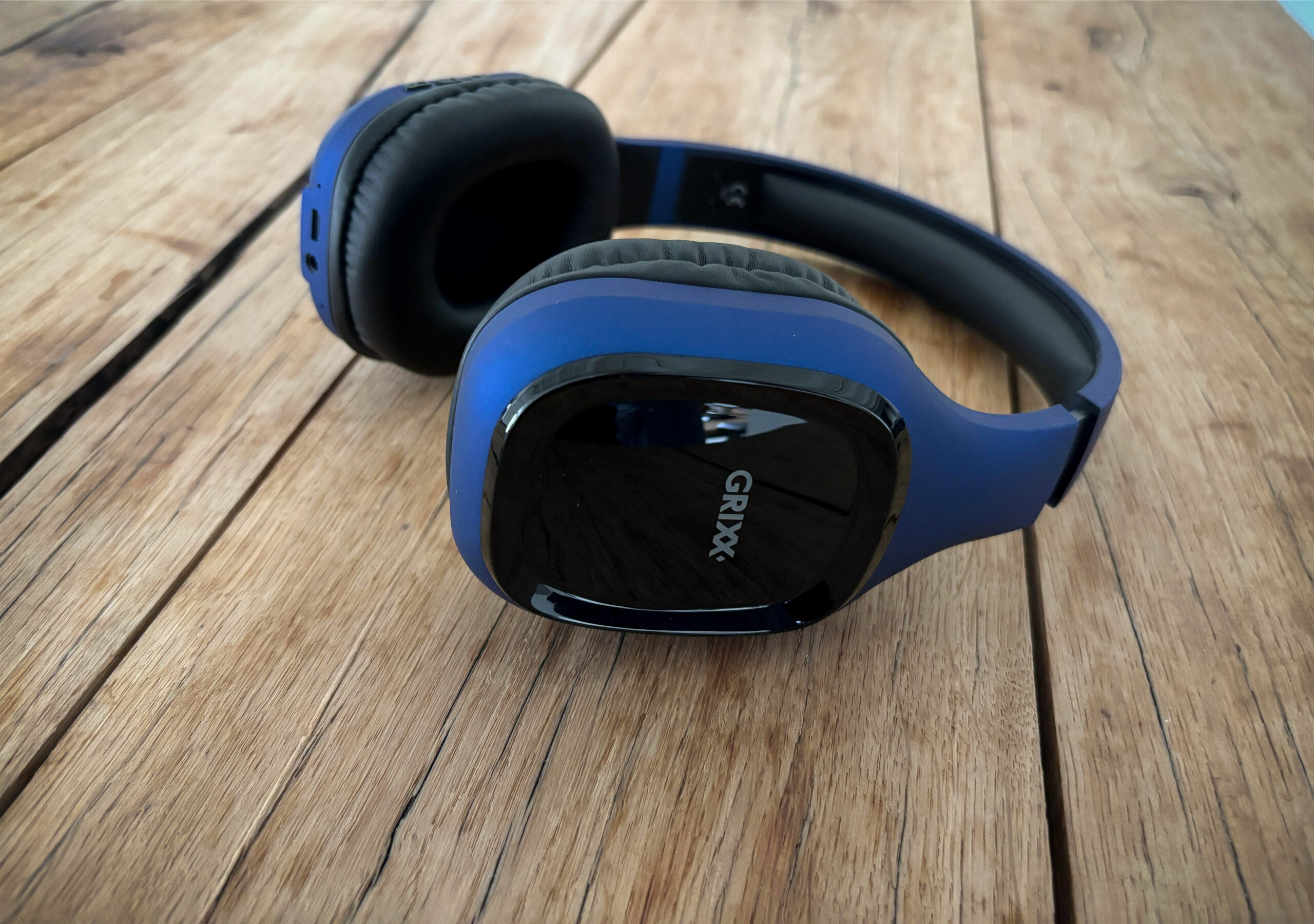 Een blauwe over ear headphone van Grixx op een tafel