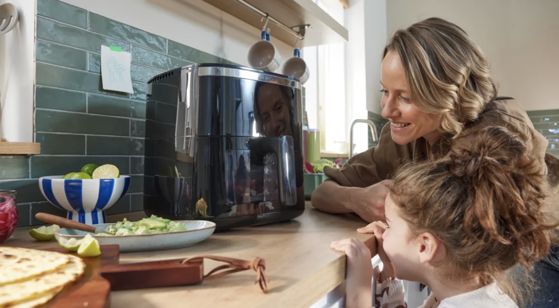 Een vrouw en een kind kijken naar Bosch Airfryer Serie 6