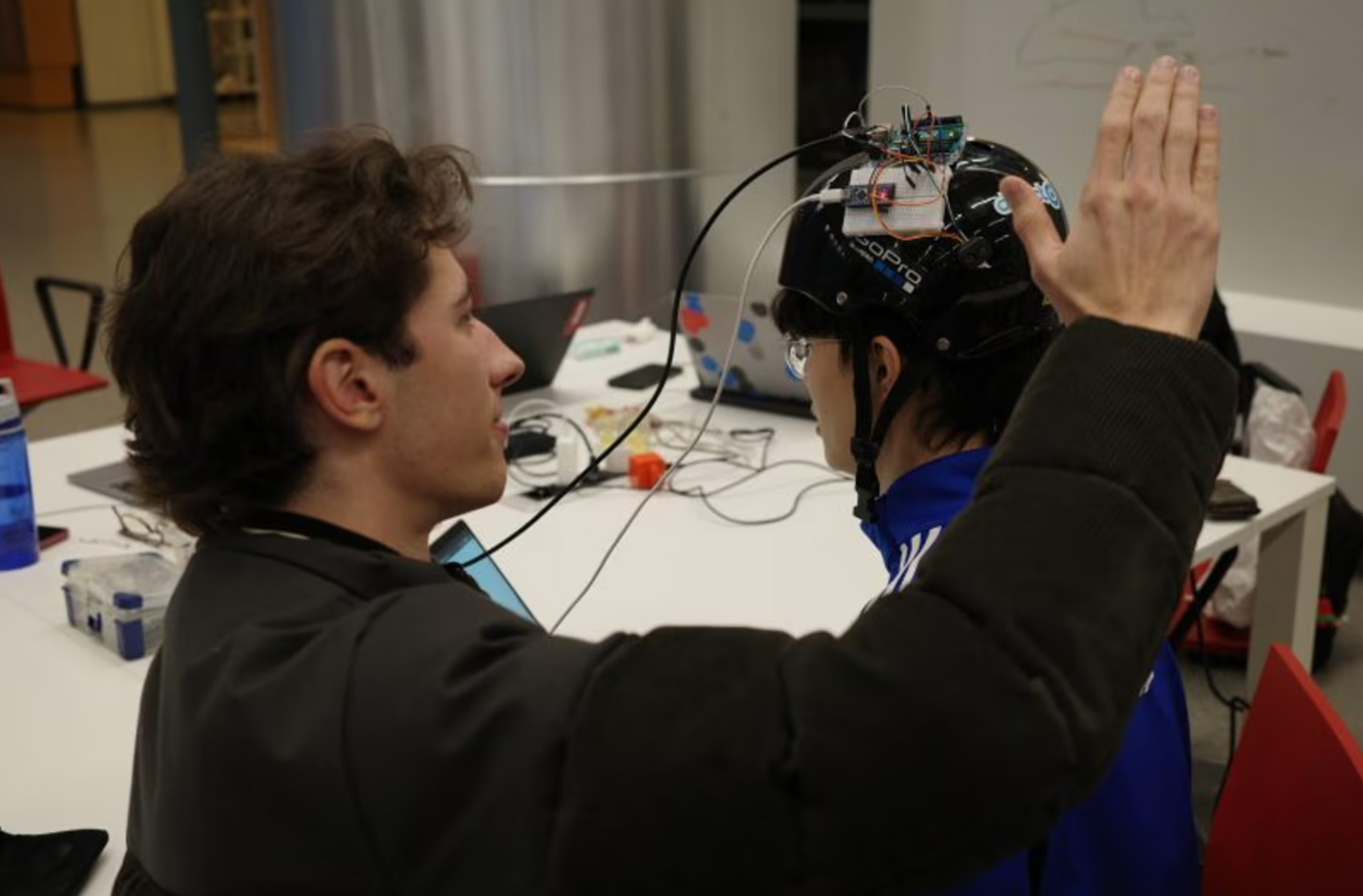 Iemand met een bijzondere helm op die allerlei dingen kan doen.