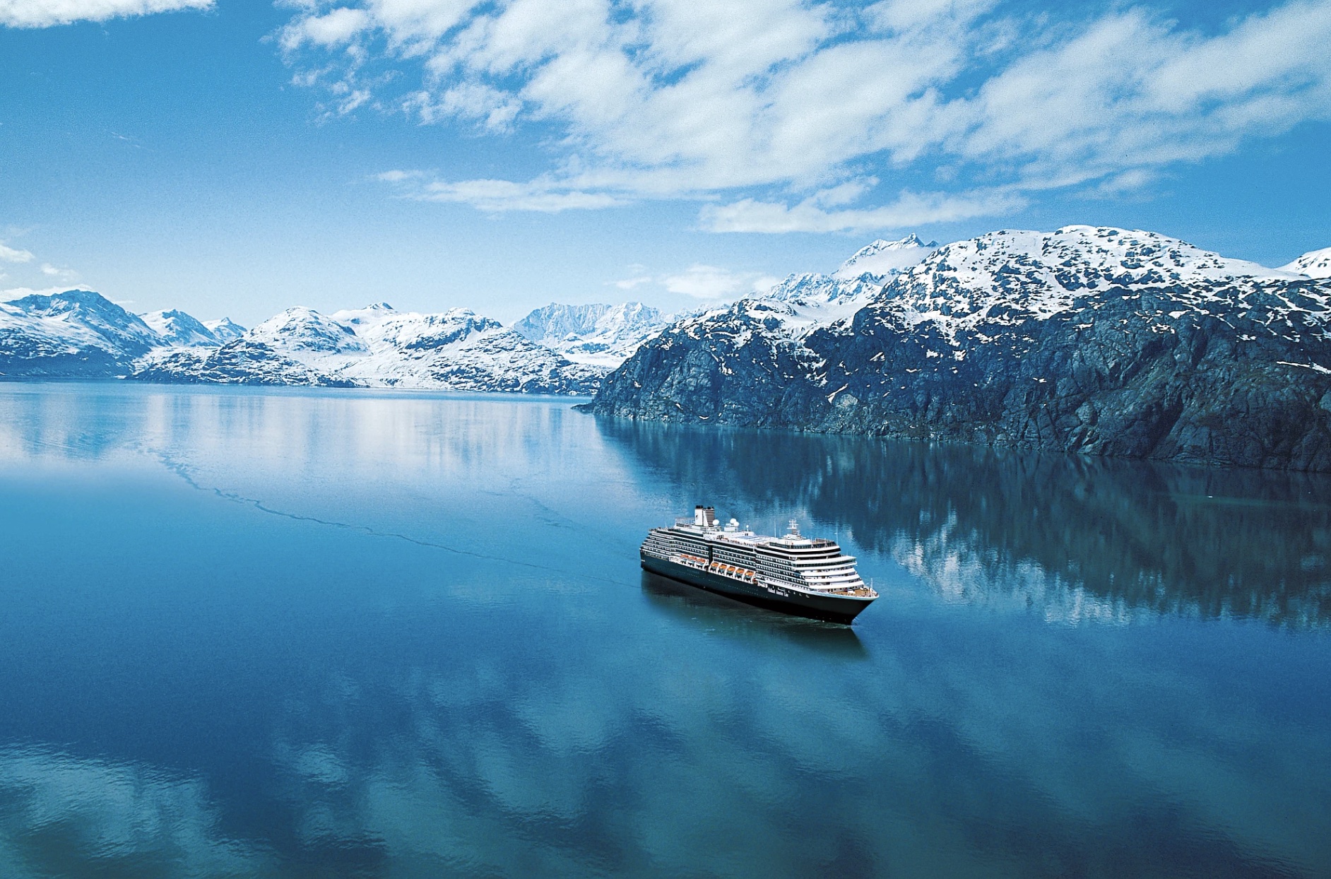 Een cruisseschip bij bergen met sneeuw
