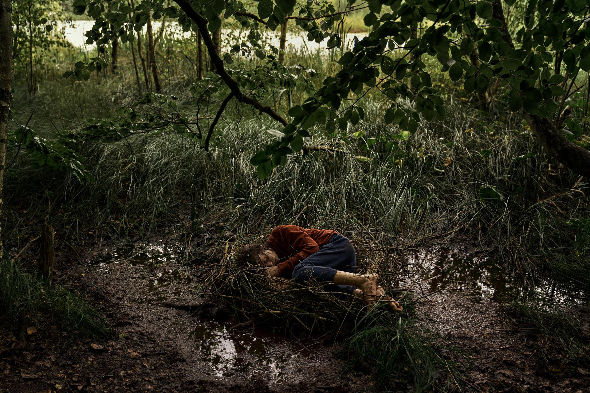 Iemand ligt in het bos in de serie The Chestnut Man Hide and Seek