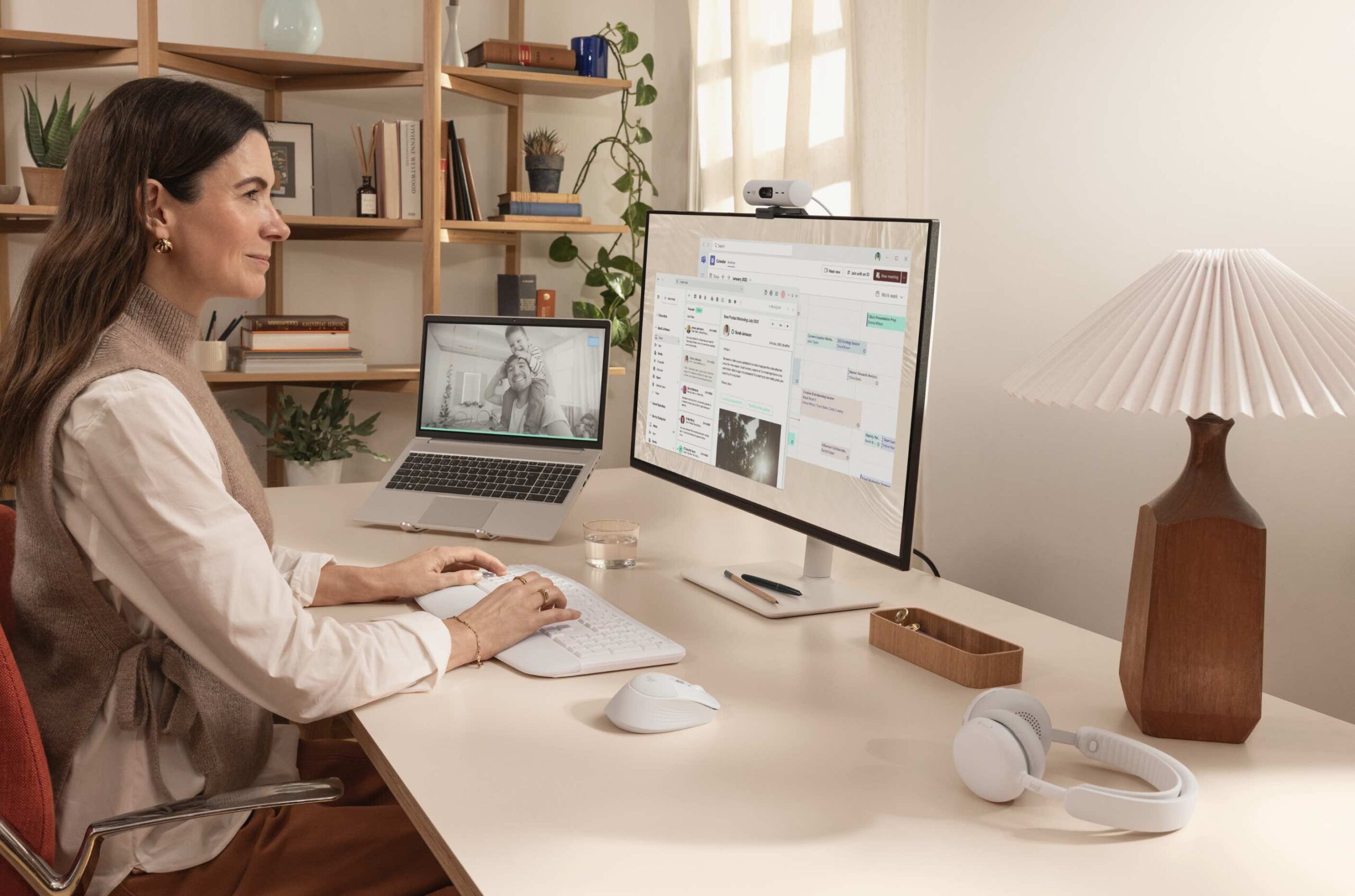 Een vrouw is hard aan het werk. Ze kijkt naar een computer. Naast haar een logitech muis met zacht kussentje ter ondersteuning.
